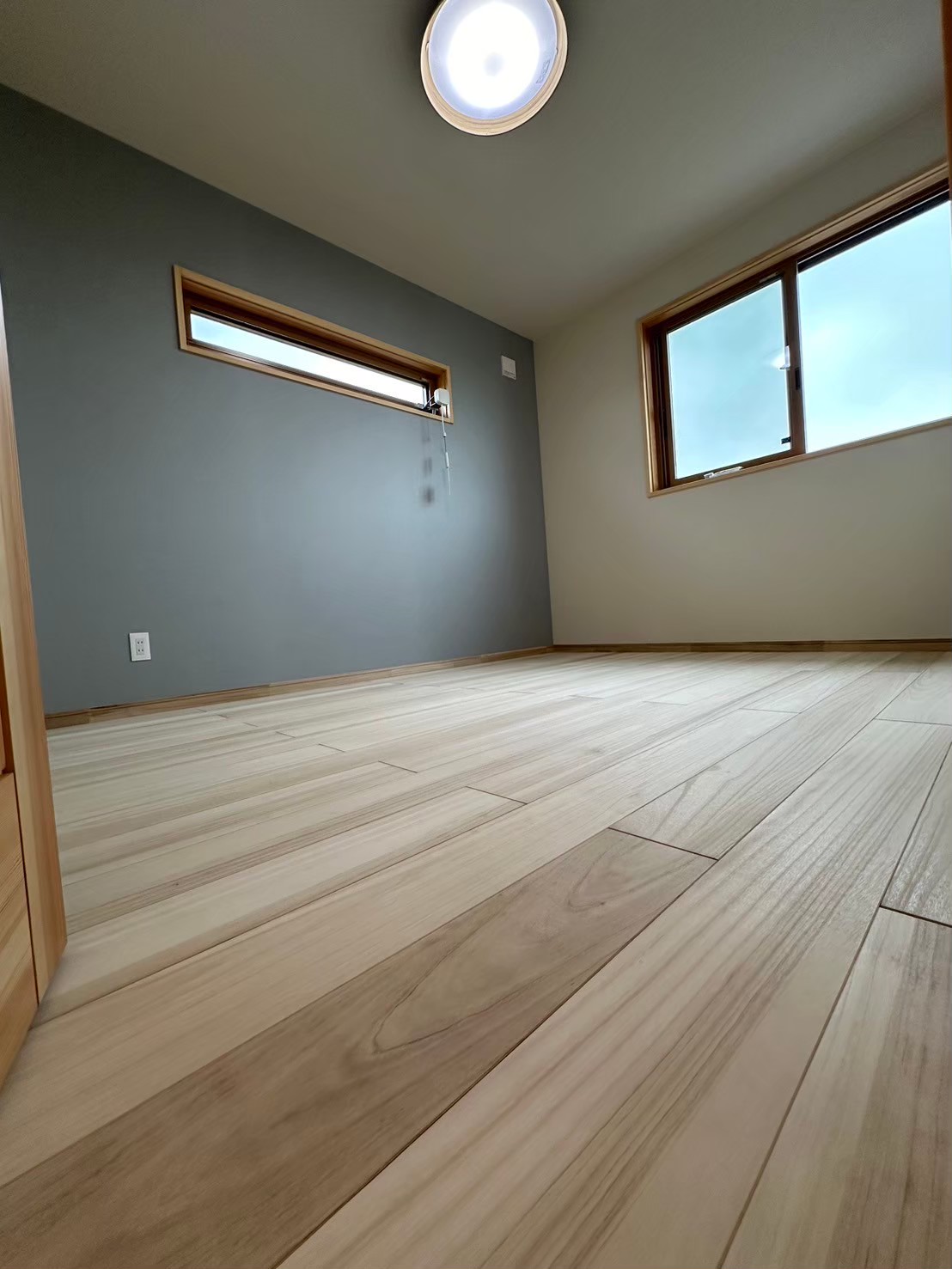 子供部屋を考えて作った洋室。壁紙は落ち着いたブルーを選択。机やベッドを置いても邪魔しない横長の窓が素敵です。