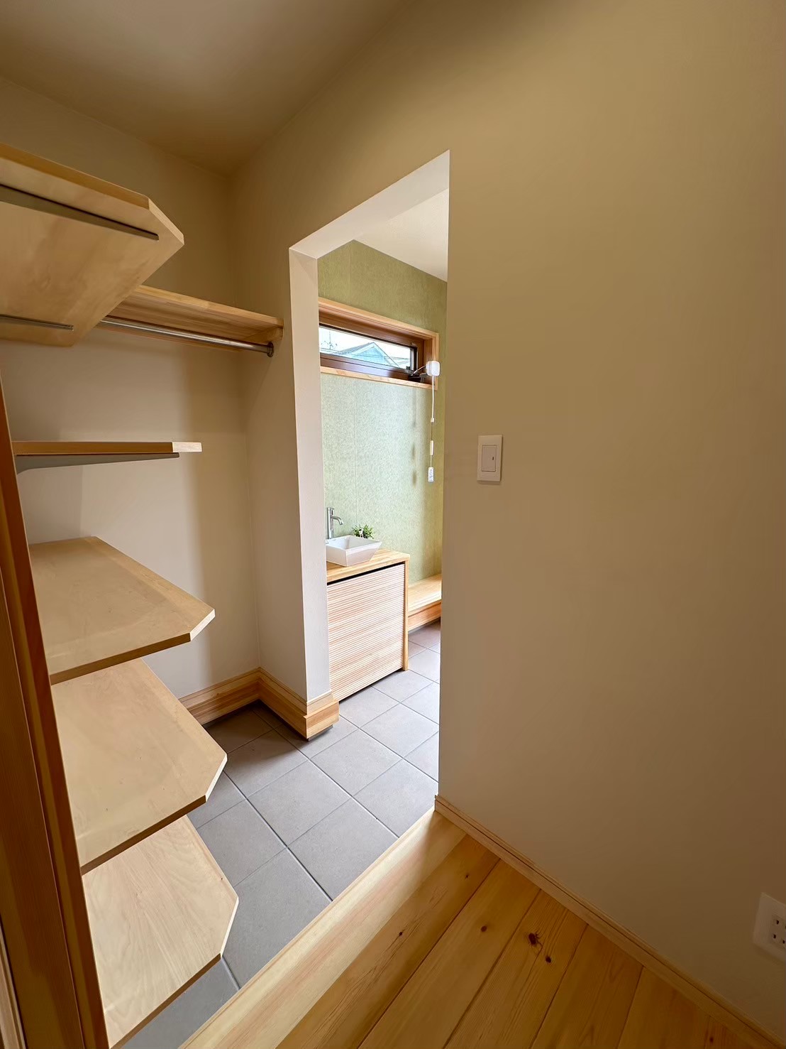 玄関入って正面には、収納抜群の収納棚とハンガーポールを作りました。そして、そこから直接キッチンにも行ける工夫を。無駄のない家事同線を実現した間取り。